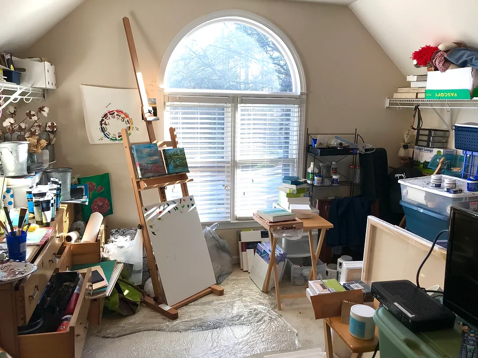 Extremely cluttered art studio with canvases, easels, and paint supplies before Imagine Organizing's service — Closet Organizing in Forest Park