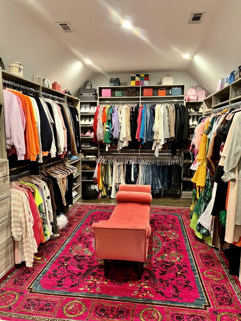 Luxury walk-in closet fully organized with designer handbags, shoes, and color-coded hanging clothes by Imagine Organizing