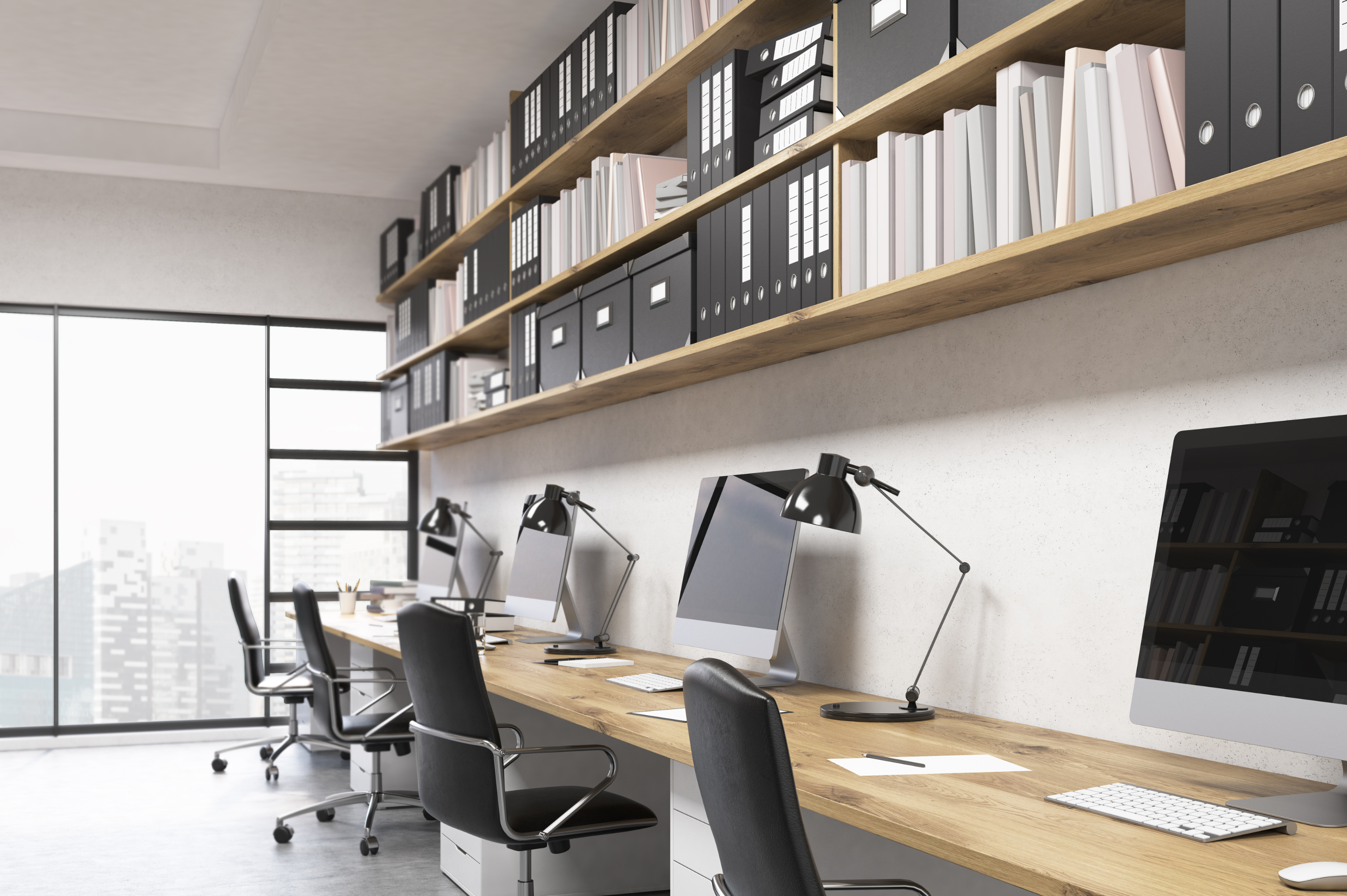Office bookshelf with binders and books above a row of desks and computer monitors — Business Organizing in Union City