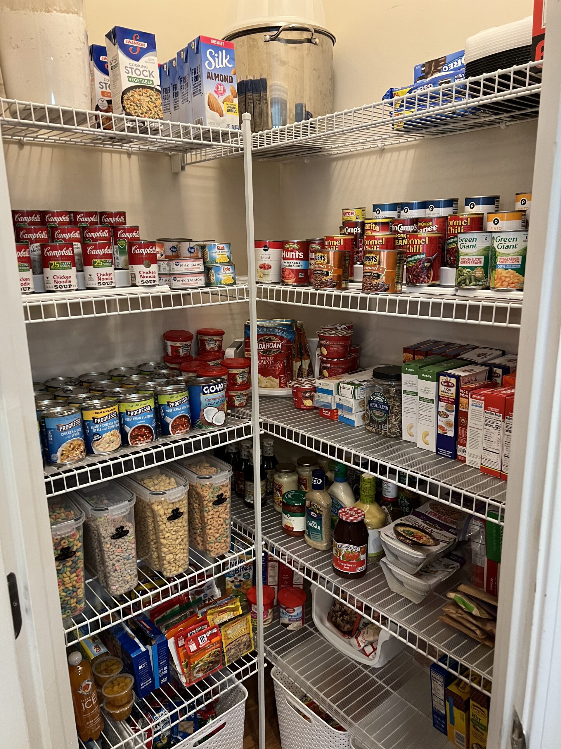 Organized pantry shelving with canned soups, cereal canisters, and snacks grouped by category by Imagine Organizing — Home Organizing in Avondale Estates