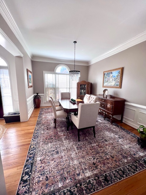 Elegant dining room with a chandelier, area rug, and antique sideboard — Interior Design in Doraville