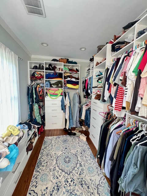 Closet with shelving, hanging clothes, and a dresser before full organizing by Imagine Organizing — Closet Organizing in Decatur