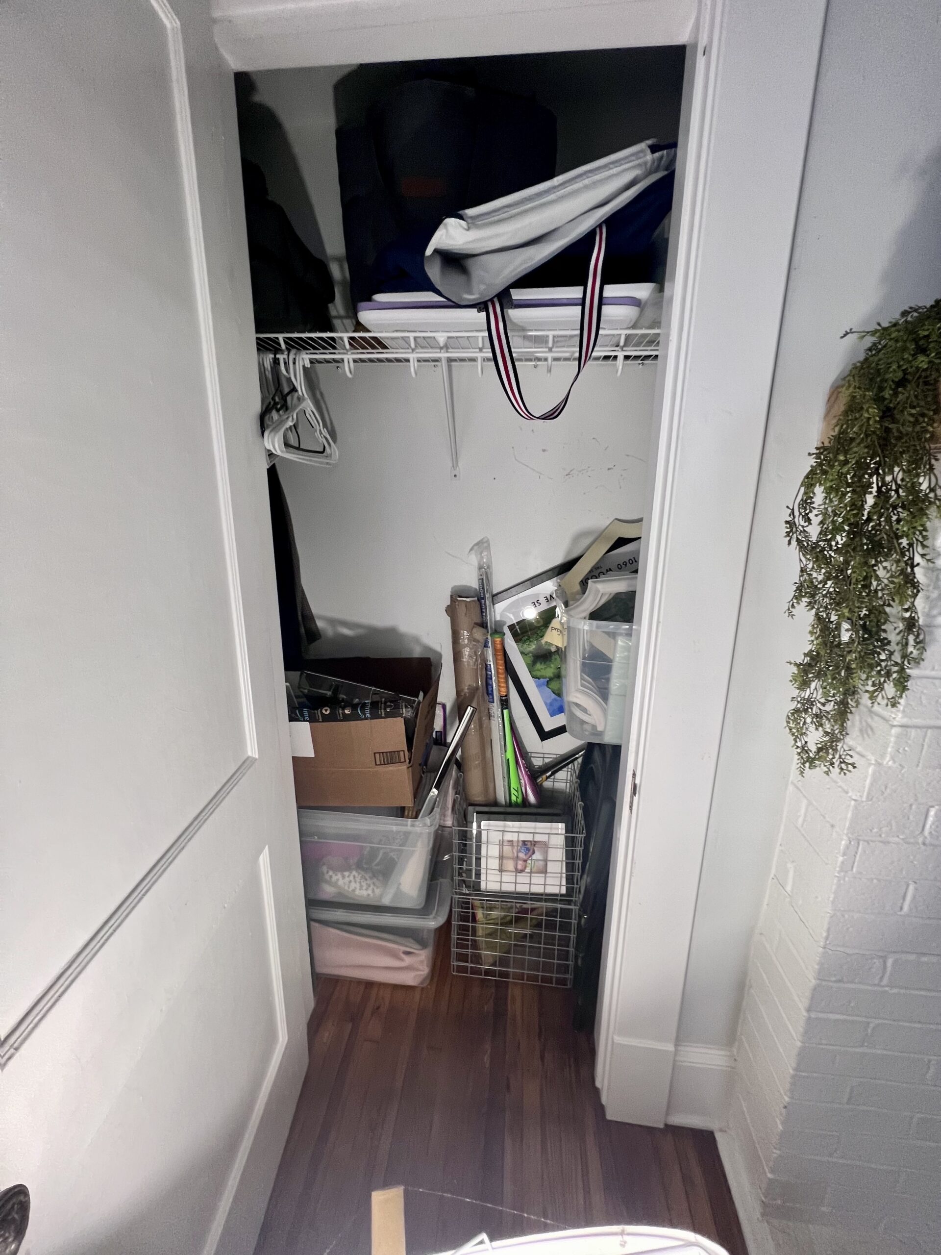 Cluttered closet with boxes, picture frames, and bins before Imagine Organizing's home organizing service — Closet Organizing in Marietta