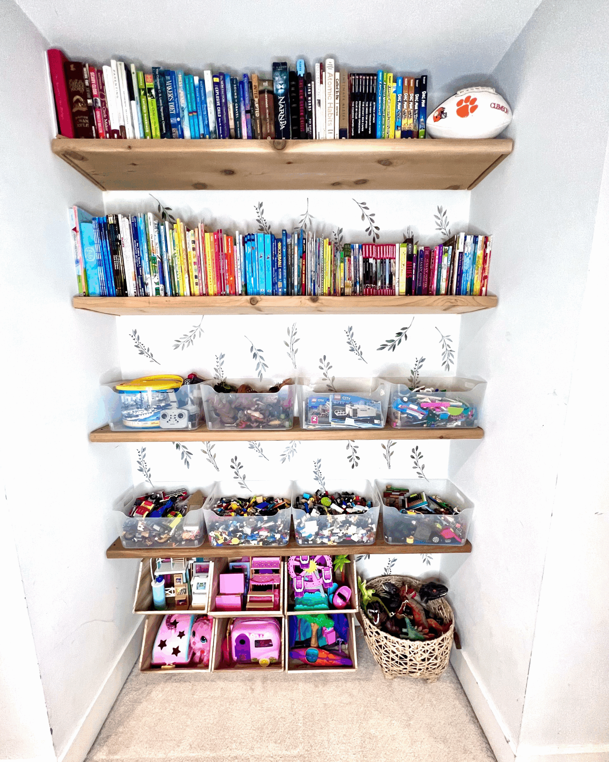 Organized kids' closet shelving with labeled Lego and toy bins, books, and a dollhouse, organized by Imagine Organizing