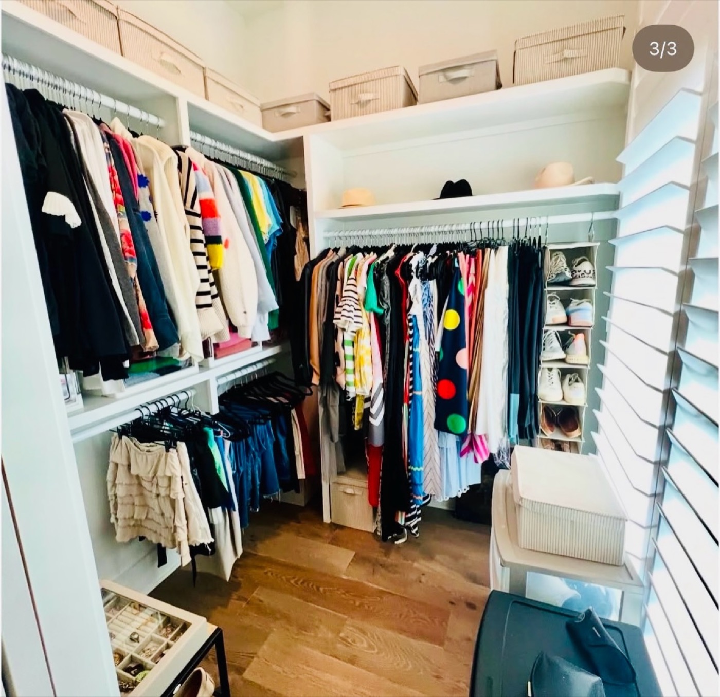 Organized walk-in closet with baskets on high shelves, shoe rack and neatly hung clothes by Imagine Organizing — Interior Design in Clarkston