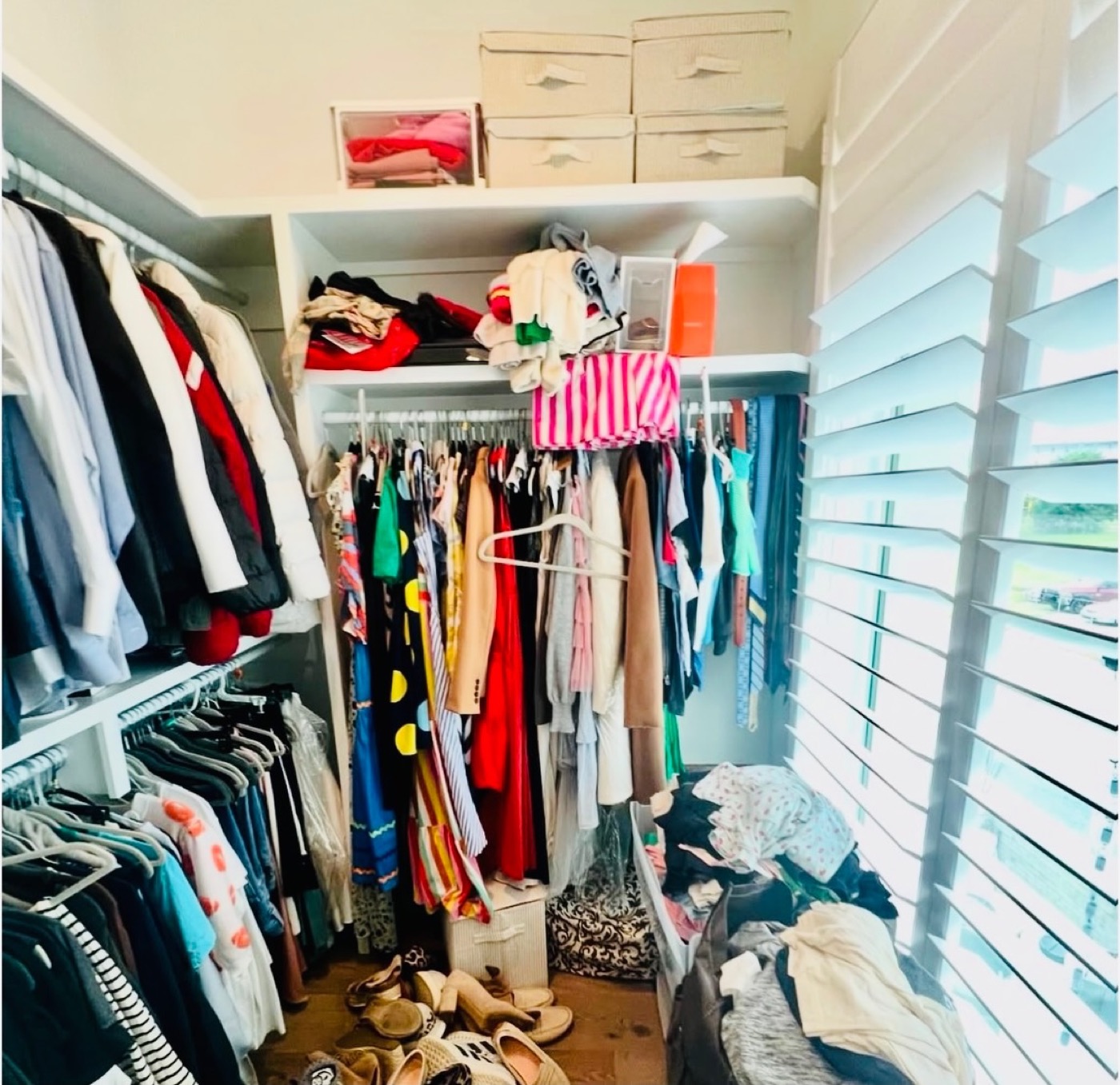 Overflowing walk-in closet with clothes piled on the floor and crowded shelves before organizing — Closet Organizing in Forest Park