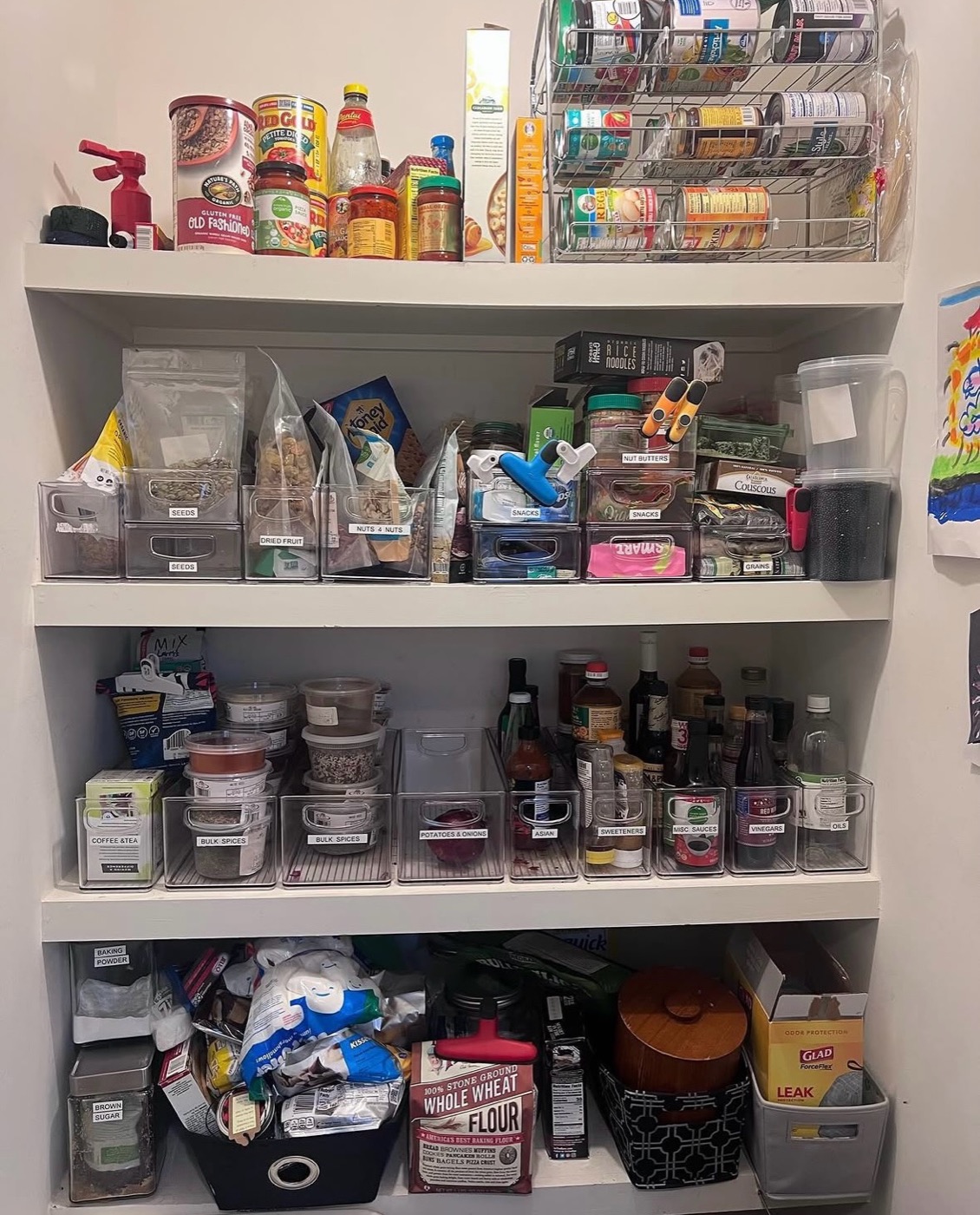 Pantry shelves being organized with clear labeled bins for snacks, baking goods and condiments — Home Organizing in Roswell